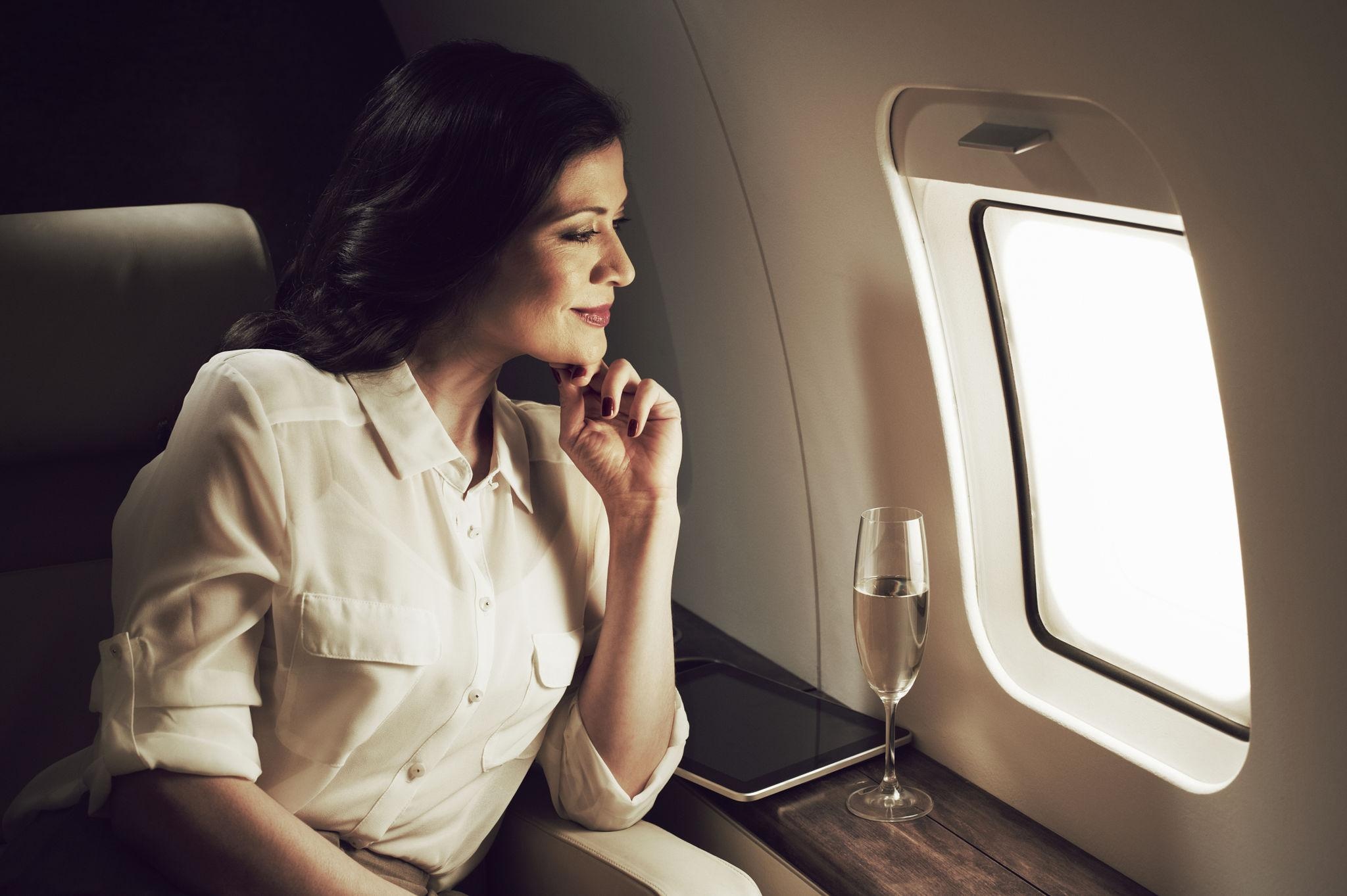 Discreet private jet passenger looking out window